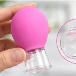 Elde tutulan pembe silikon yüz masaj kupası ve şeffaf vakum başlığı